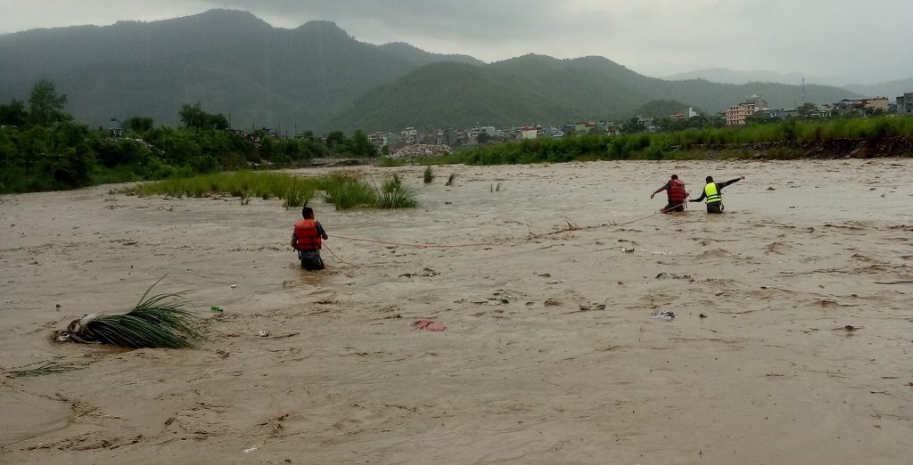 बाढीले बगाएर ल्याएको दाउरा बटुल्न जाँदा श्रीमतीलाई खोलाले बगायो, श्रीमान घाइते